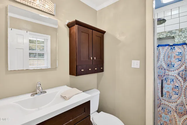 a bathroom with a sink toilet and a mirror
