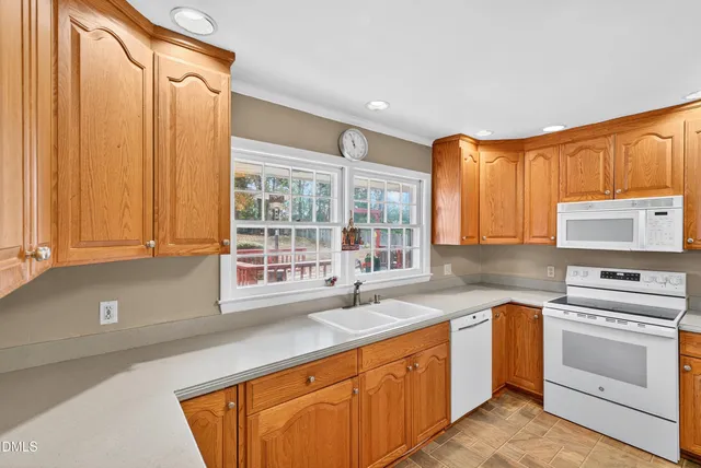 a kitchen with stainless steel appliances granite countertop a sink a stove and a refrigerator