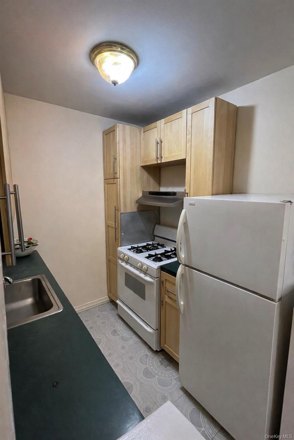 84-01 Main Street, Unit 311 Queens, NY 11435 - Photo 3 of 9 a kitchen with a refrigerator a stove a sink a washer dryer and a refrigerator