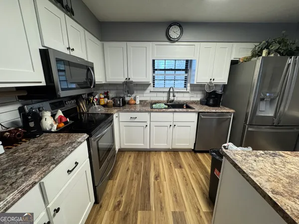 a kitchen with a sink a stove and cabinets