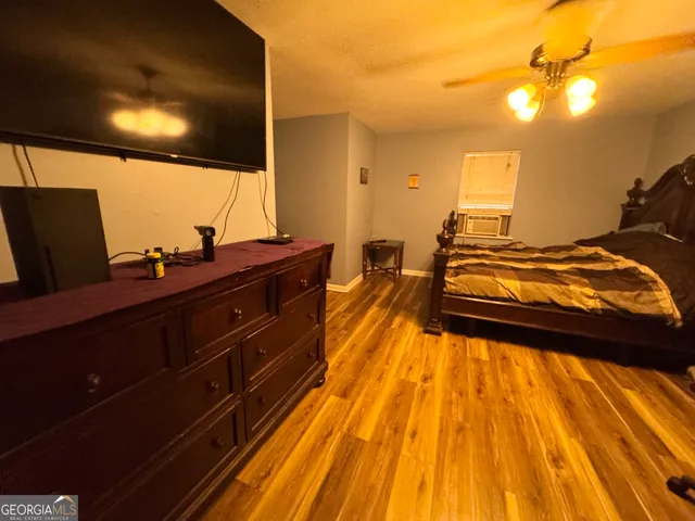 a spacious bedroom with a bed and wooden floor