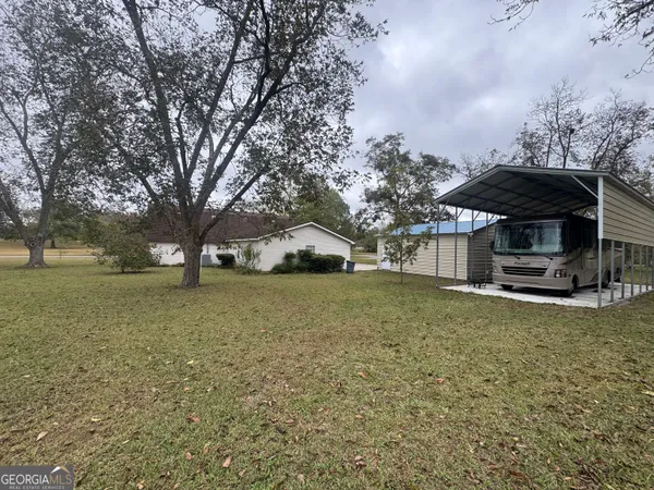 a view of a house with backyard and trees