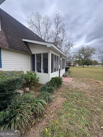 a front view of house with yard and trees around