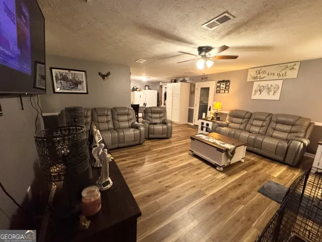 a living room with furniture a large window and gym equipment
