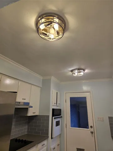 an empty room with wooden floor and chandelier
