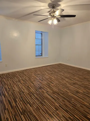 a view of a room with wooden floor and a fan