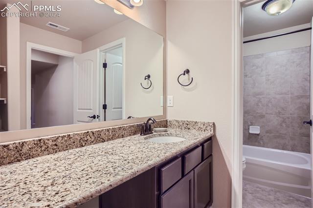 11399 Rill Point Colorado Springs, CO 80921 - Photo 23 of 28 Full bathroom featuring tiled shower/bath, tile floors and vanity