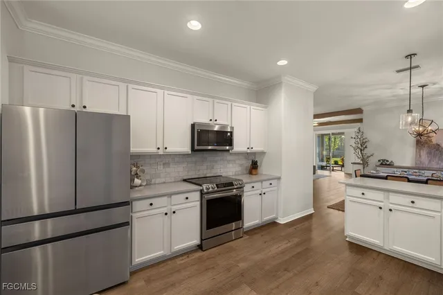 a kitchen with granite countertop white cabinets and stainless steel appliances