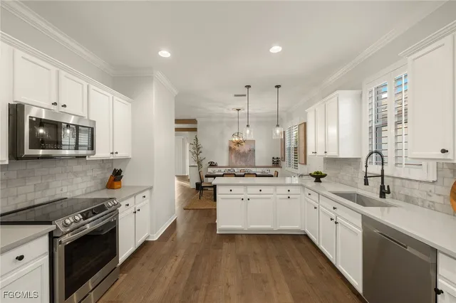 a kitchen with stainless steel appliances sink a stove and cabinets