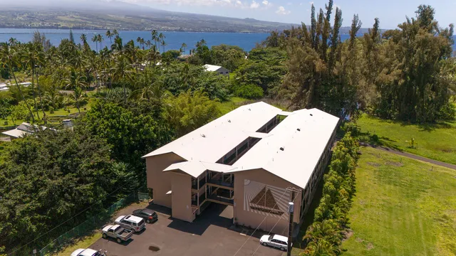 an aerial view of a house with garden space and a building