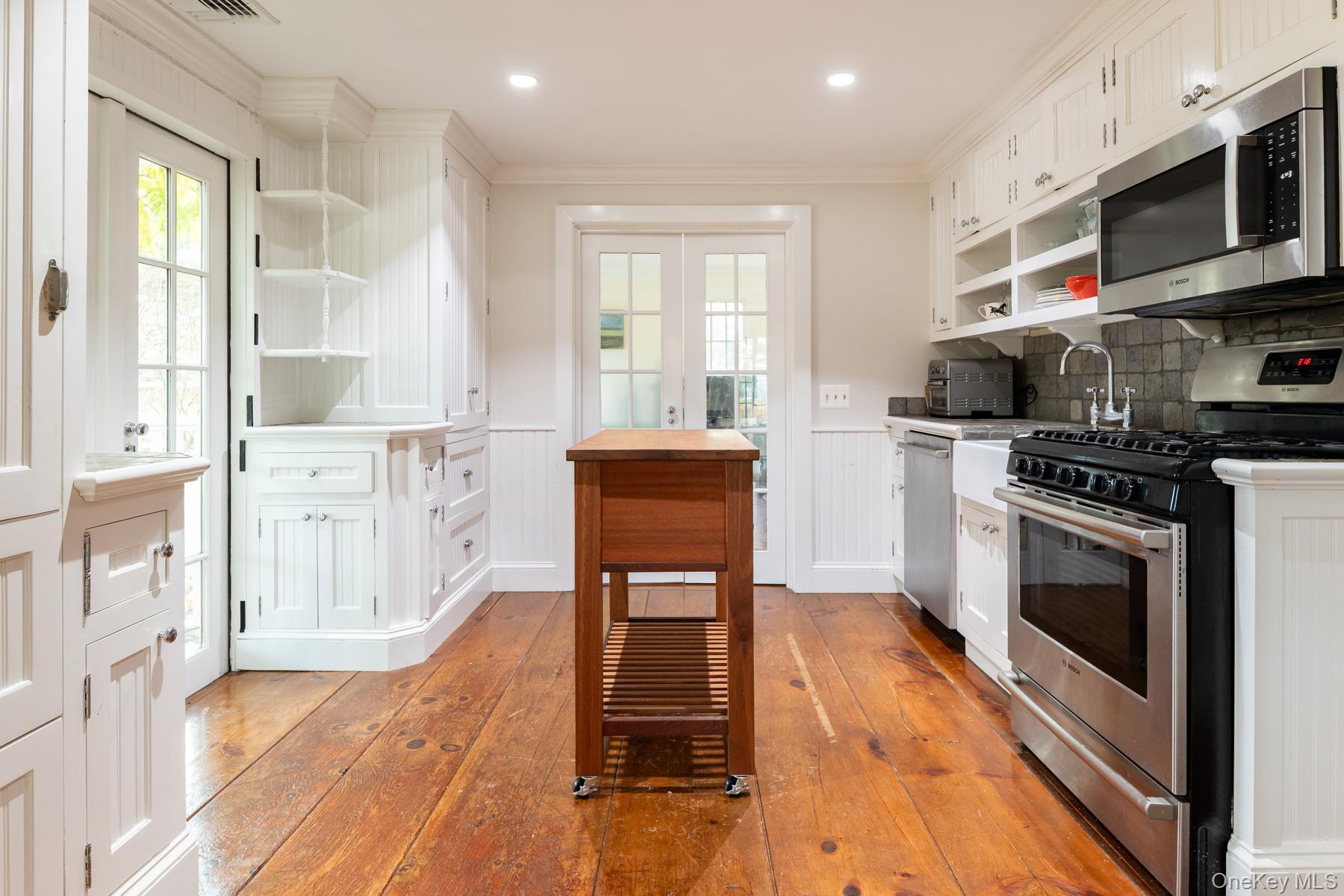 11 Carriage House Road Waccabuc, NY 10597 - Photo 28 of 39 a kitchen with stainless steel appliances a stove a sink cabinets and a wooden floor