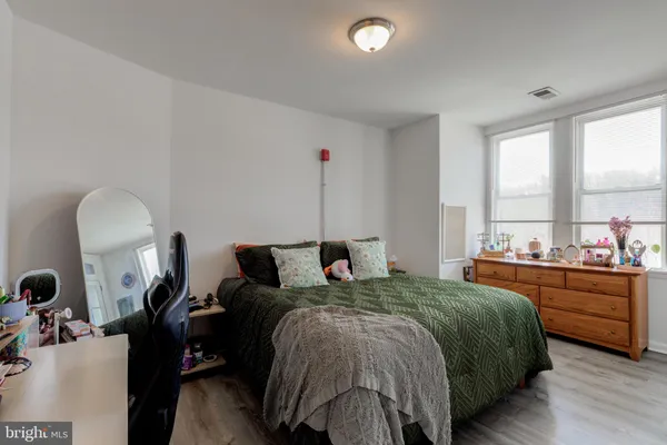a bedroom with a bed and wooden floor