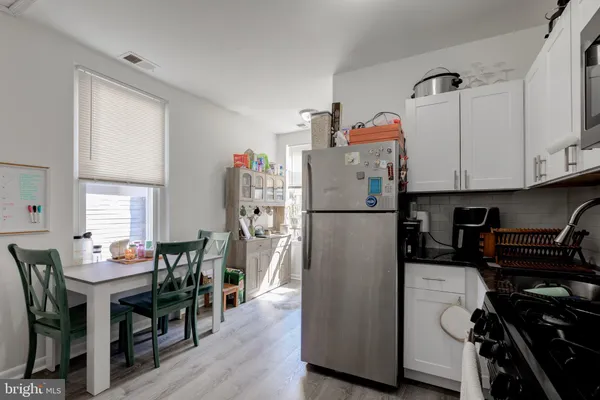a kitchen with stainless steel appliances granite countertop a refrigerator and a stove top oven