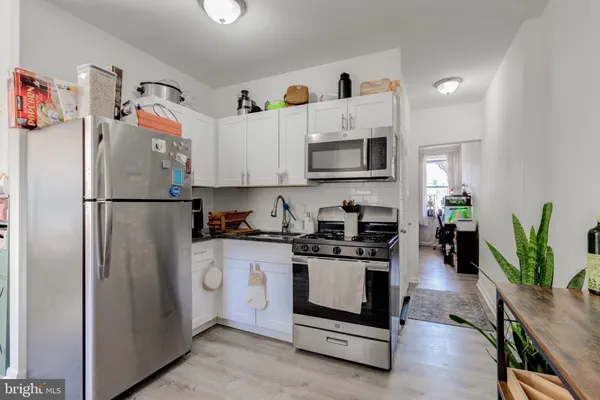 a kitchen with stainless steel appliances a stove a refrigerator a sink a stove and cabinets
