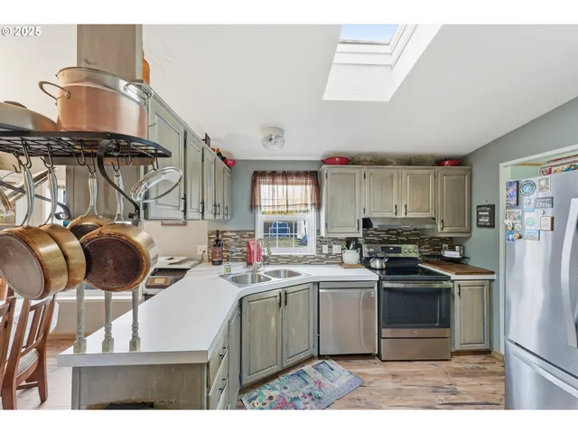 a kitchen with a sink a stove a refrigerator and black cabinets