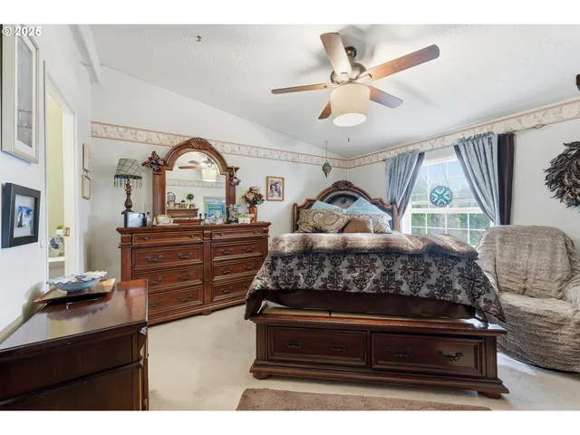 a bed room with a bed and a ceiling fan