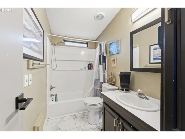 a bathroom with a sink a toilet a mirror and shower