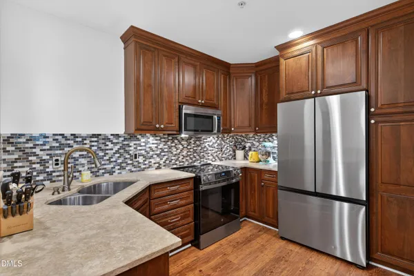 a kitchen with stainless steel appliances granite countertop a refrigerator stove a sink and dishwasher
