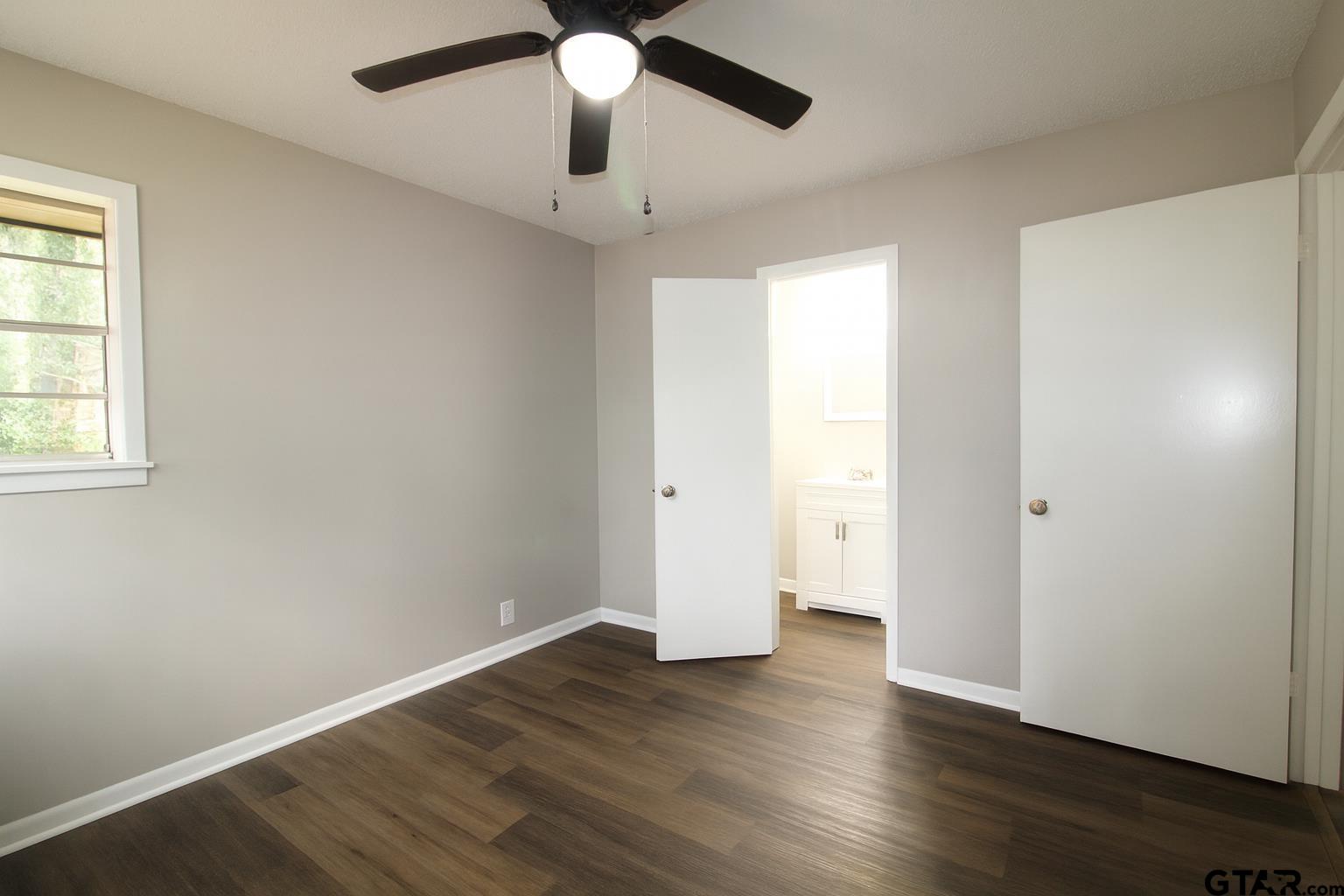 149 County Road 4237 Jacksonville, TX 75766 - Photo 14 of 19 an empty room with wooden floor and windows
