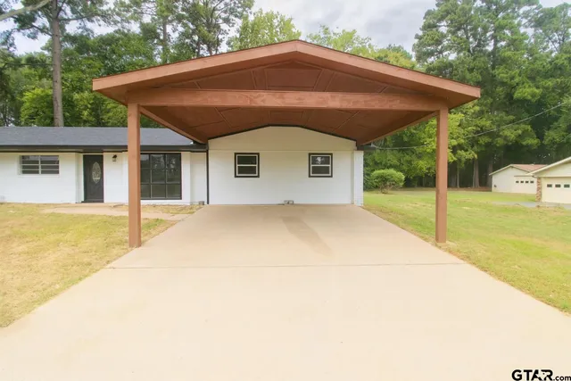 a view of a house with backyard and trees