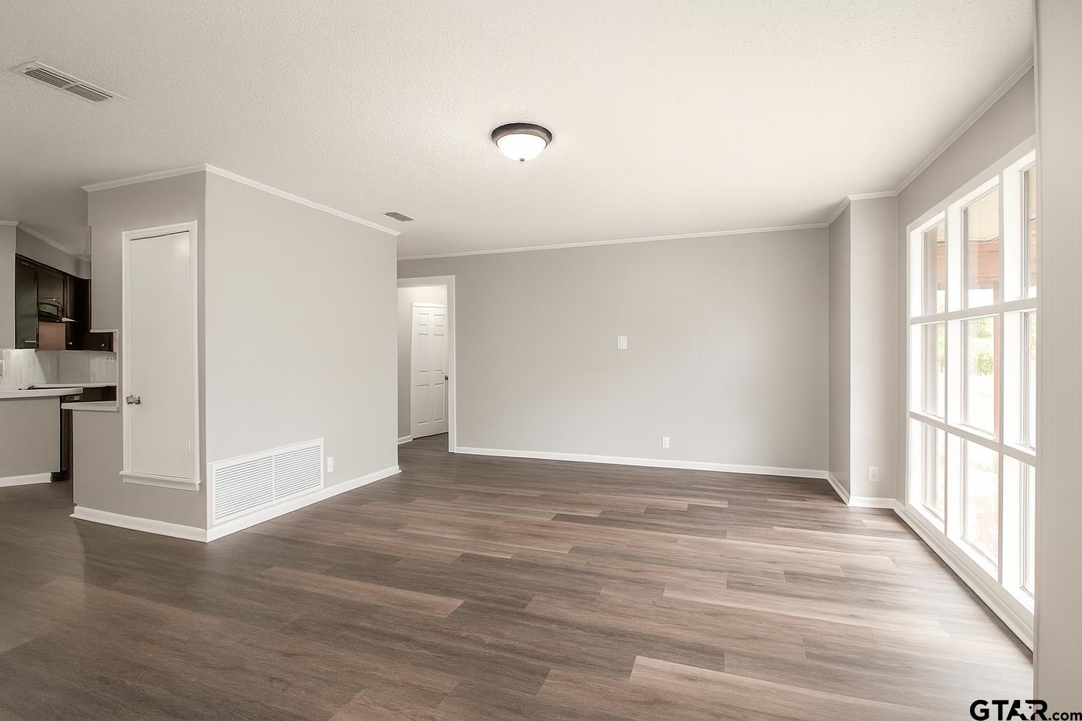 149 County Road 4237 Jacksonville, TX 75766 - Photo 3 of 19 a view of an empty room with wooden floor and a window