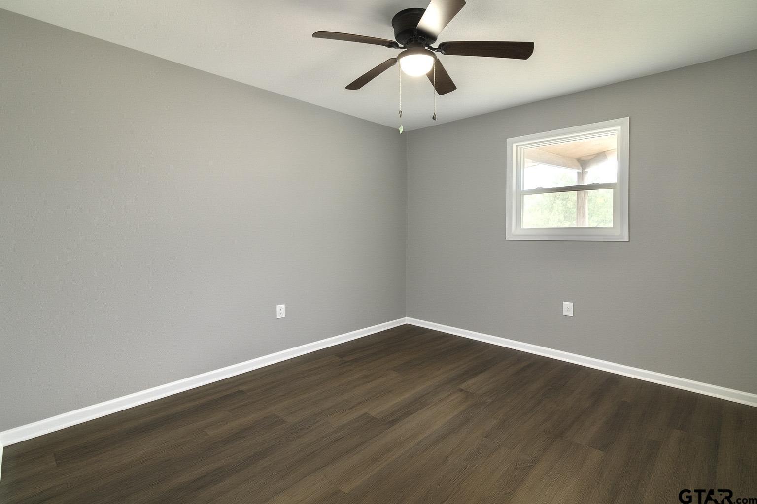 149 County Road 4237 Jacksonville, TX 75766 - Photo 10 of 19 a view of an empty room with wooden floor and a window