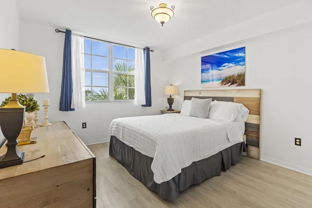 a bedroom with a bed a dresser next to a window