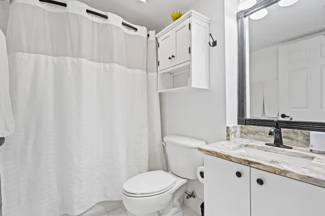 a bathroom with a granite countertop sink toilet and shower
