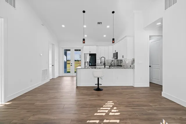 a kitchen with granite countertop a stove a sink and a refrigerator