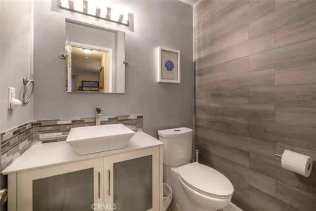 a bathroom with a toilet sink vanity and mirror