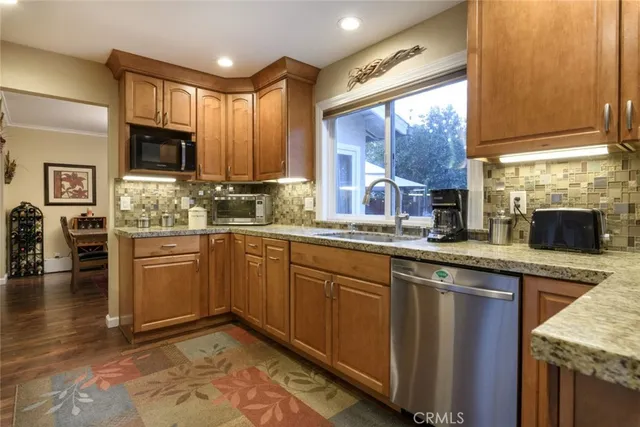 a kitchen with stainless steel appliances granite countertop wooden cabinets a sink and dishwasher