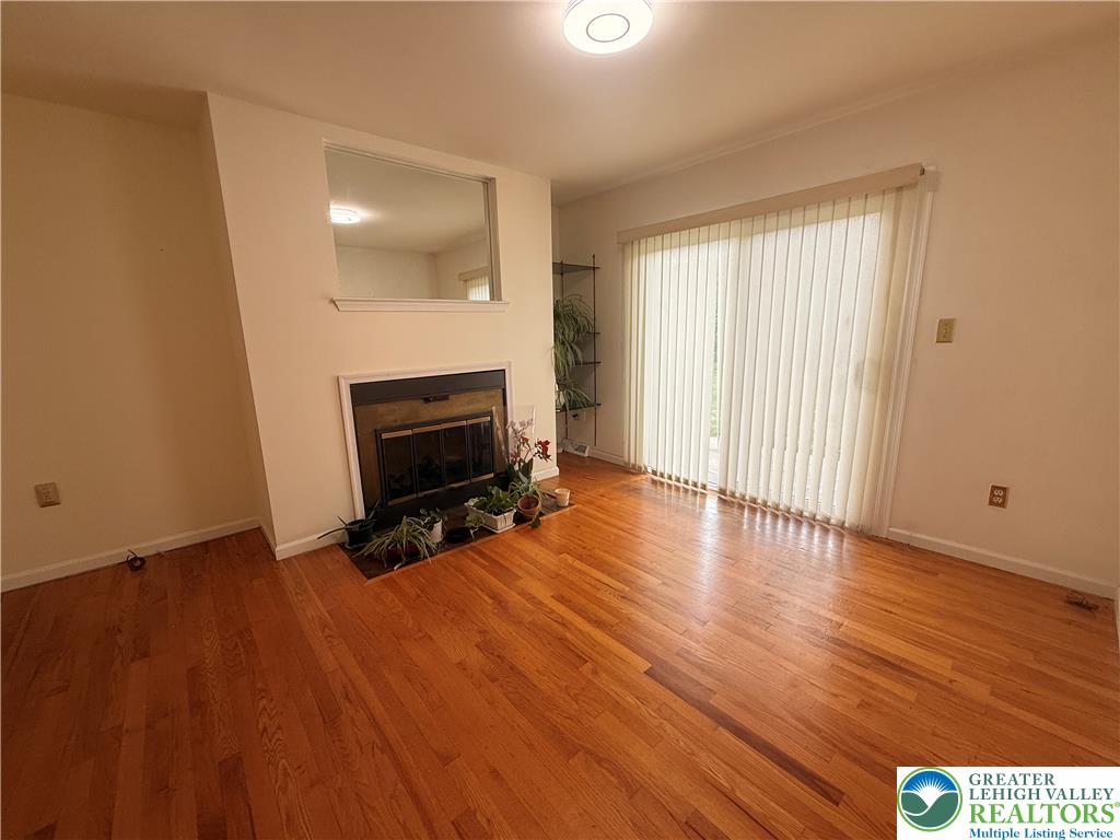 170 Springhouse Road Allentown, PA 18104 - Photo 10 of 23 Hardwood floors and a cozy fireplace provide comfort in this living room.