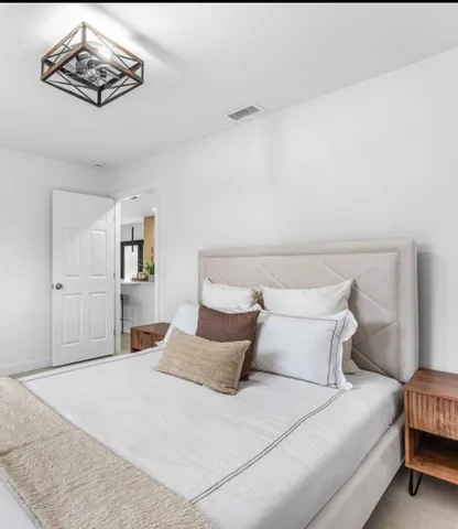 a bedroom with a bed and a chandelier