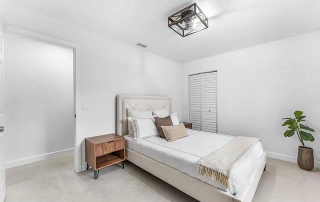 a bedroom with two beds and a chandelier