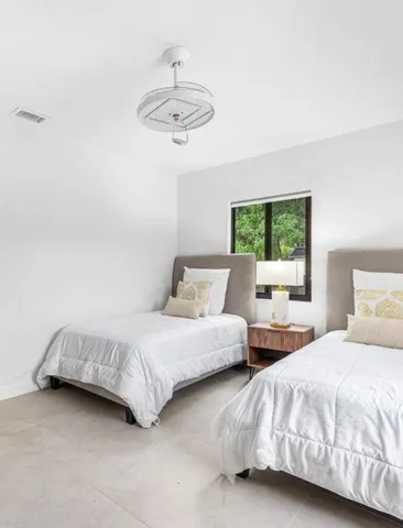 a bedroom with two beds and a large window