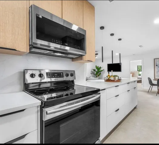 a kitchen with stainless steel appliances a stove a microwave and sink