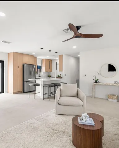 a living room with furniture and view of kitchen