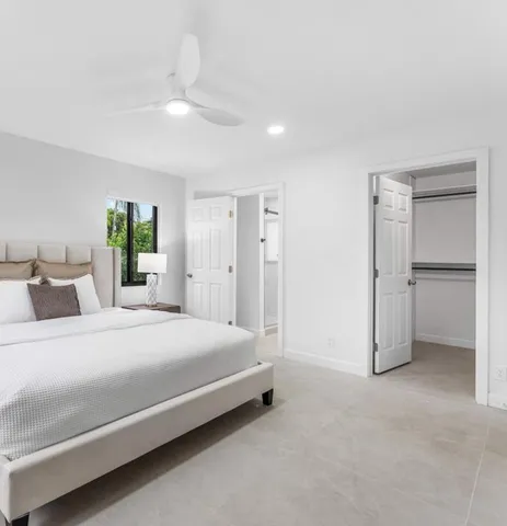 a spacious bedroom with a bed and a chandelier