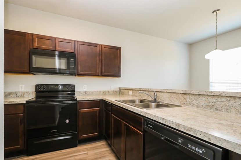 1003 Harper Lane Bryan, TX 77803 - Photo 4 of 15 a kitchen with stainless steel appliances granite countertop a sink stove and microwave