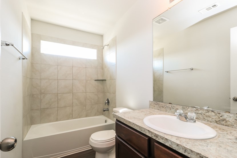 1003 Harper Lane Bryan, TX 77803 - Photo 9 of 15 a bathroom with a granite countertop sink toilet and shower