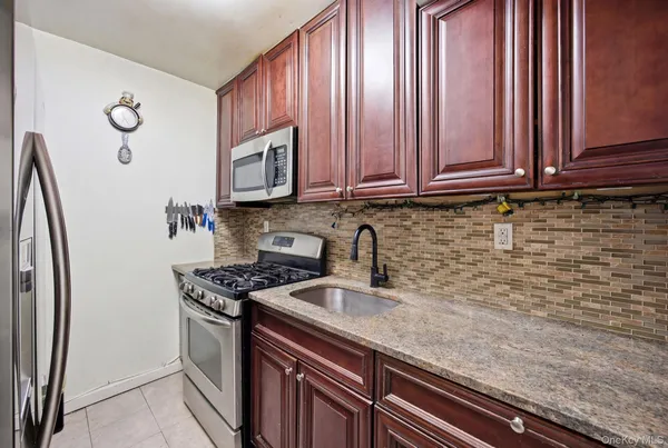 a kitchen with stainless steel appliances granite countertop a sink a stove and a refrigerator