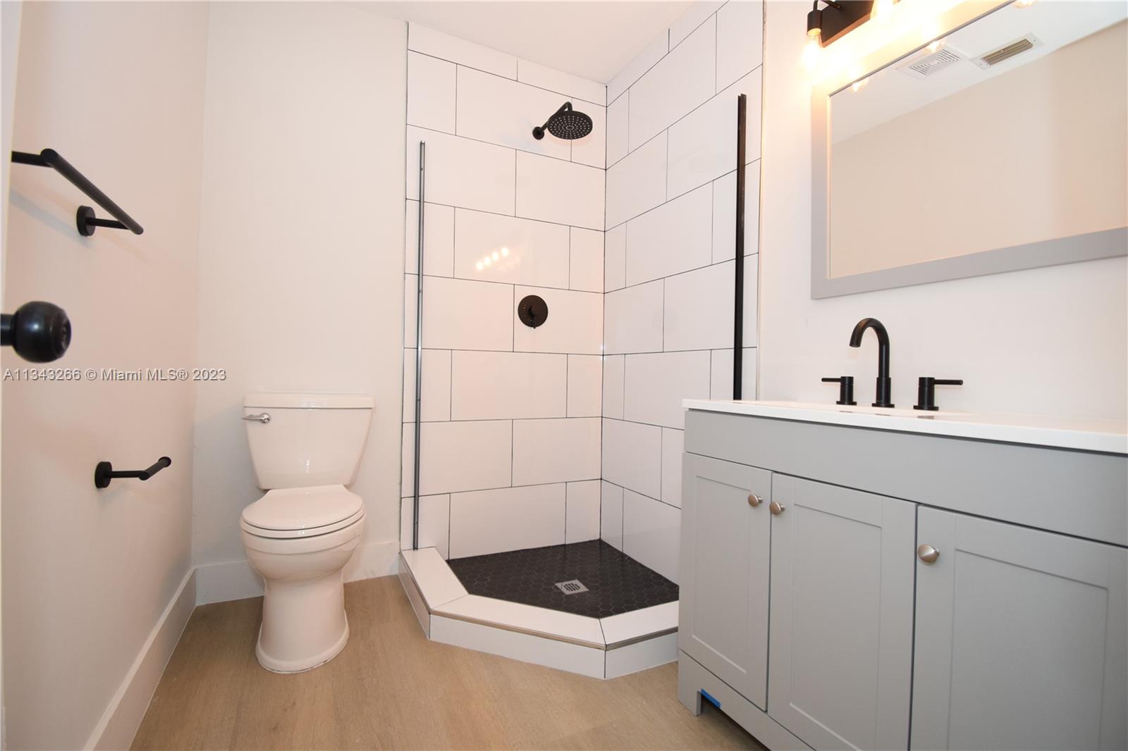 9222 Southwest 5th Street, Unit A Boca Raton, FL 33428 - Photo 8 of 34 a bathroom with a toilet a sink and a mirror