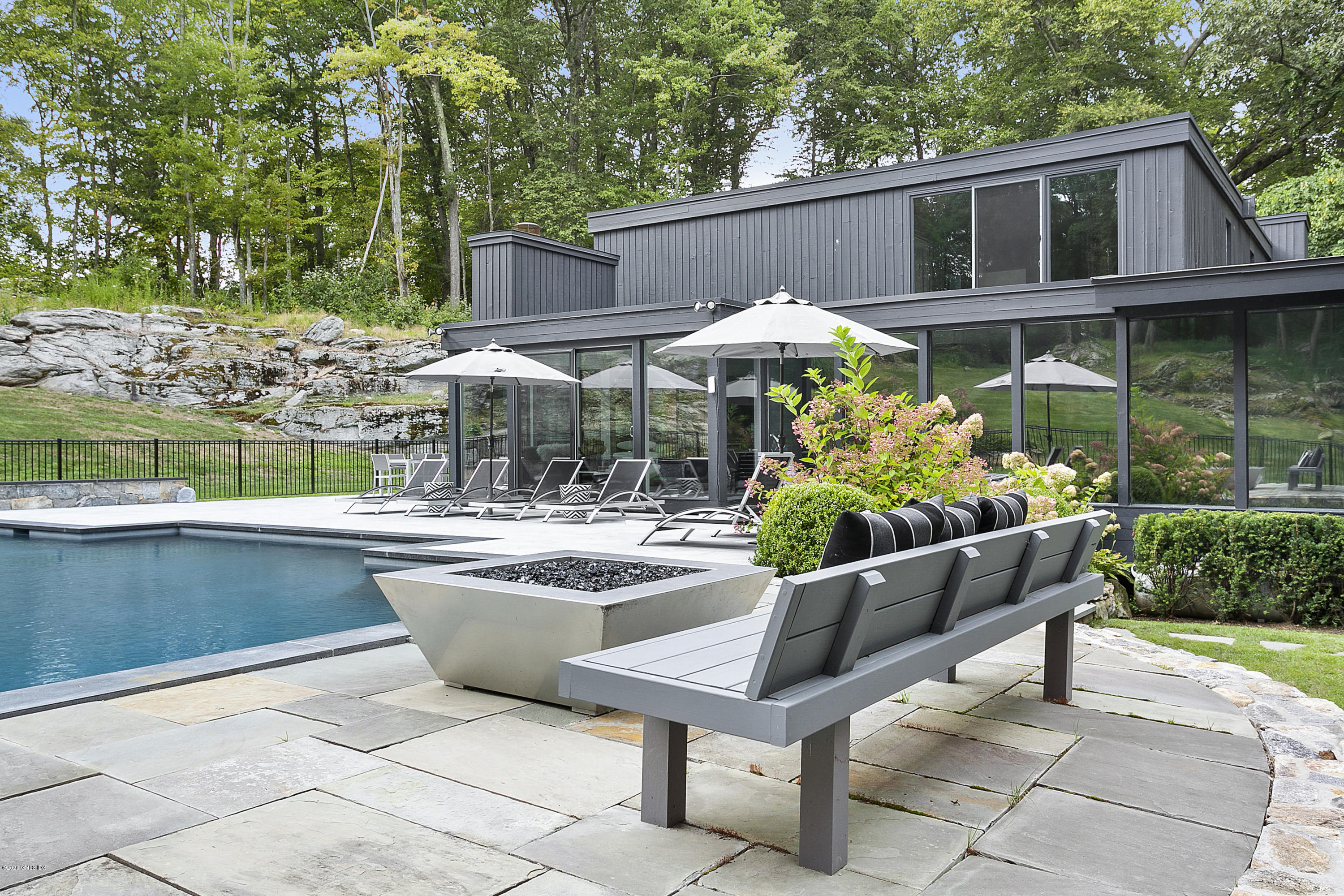 9 Chateau Ridge Drive Greenwich, CT 06831 - Photo 30 of 34 a view of a patio with couches table and chairs under an umbrella