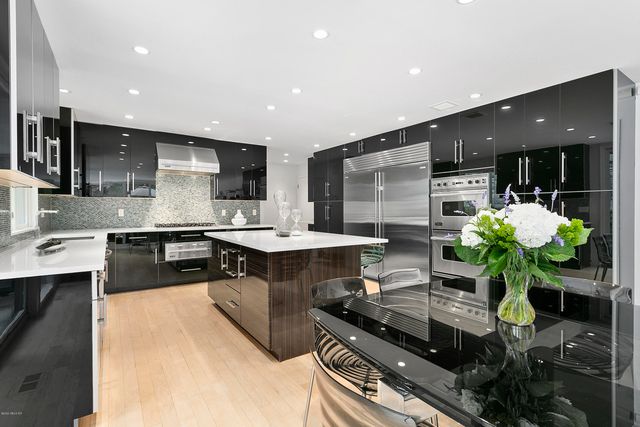 a kitchen with stainless steel appliances kitchen island granite countertop a sink dishwasher stove and cabinets