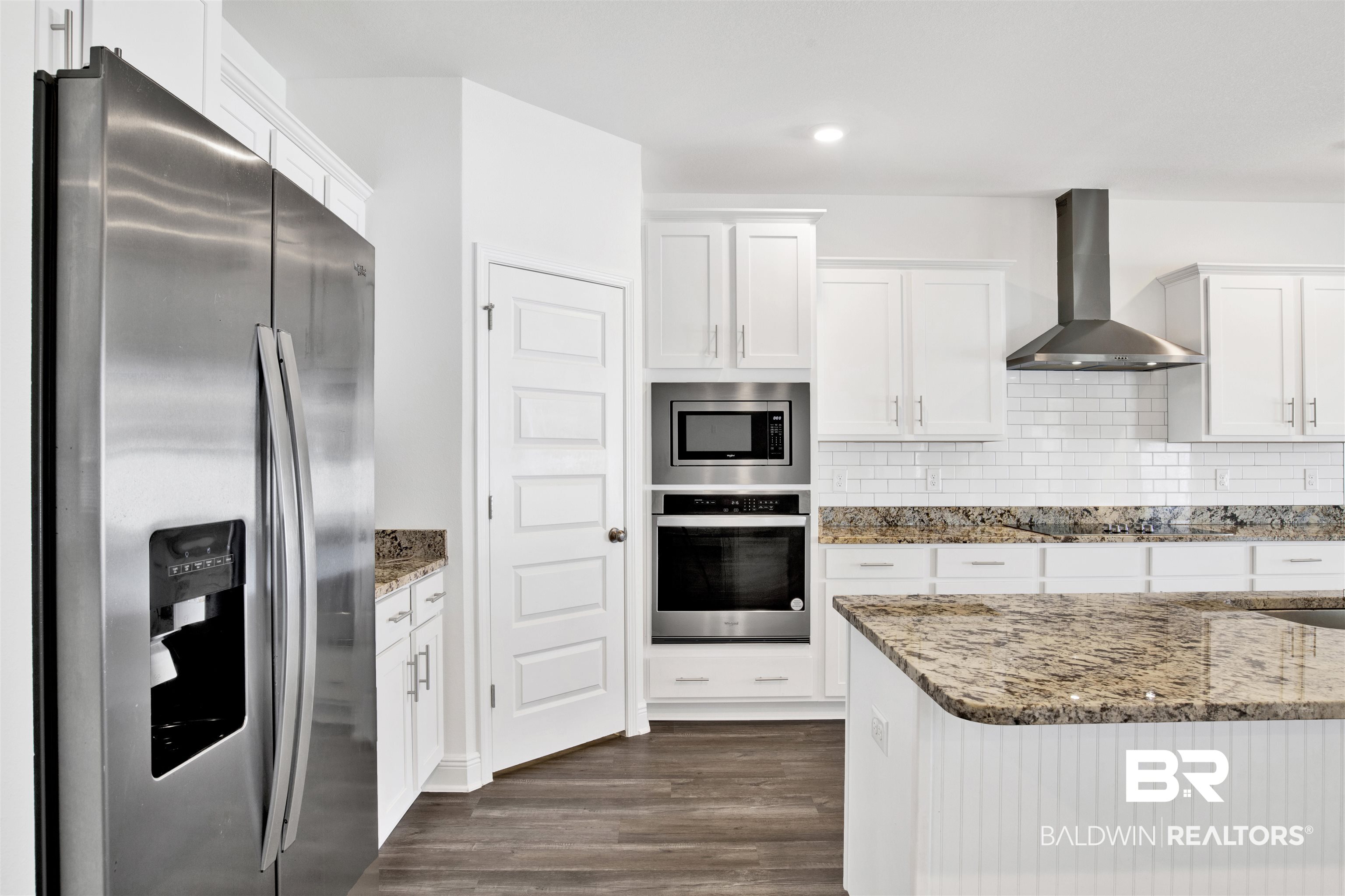 11602 Genuine Risk Circle Daphne, AL 36526 - Photo 13 of 30 Kitchen featuring light stone counters, stainless steel appliances, white cabinetry, wall chimney range hood, and recessed lighting