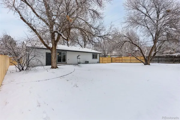 front view of house with a yard covered in snow