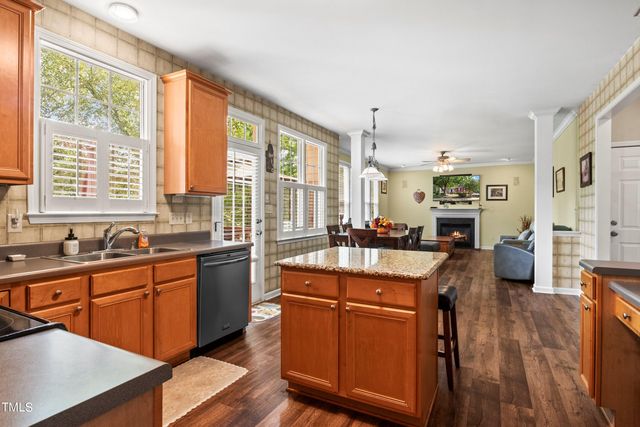 a room with stainless steel appliances granite countertop sink stove and wooden floor
