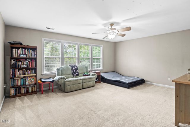a living room with furniture and a bookshelf and a large window
