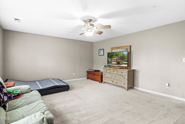 a bedroom with furniture and a chandelier fan