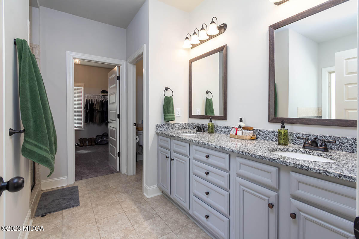 150 Homestead Circle Forsyth, GA 31029 - Photo 13 of 30 a bathroom with a granite countertop sink vanity and mirror